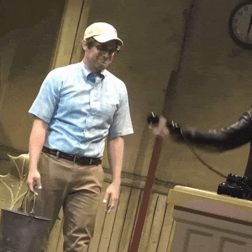 a man in a baseball cap is holding a bucket in front of a clock that shows the time as 4:20