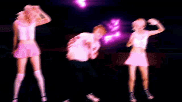 a blurry picture of three people dancing in pink clothes