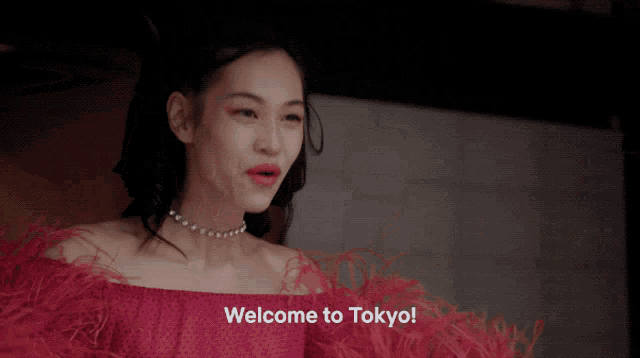 a woman in a red dress says " welcome to tokyo "