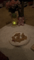a plate of cookies is sitting on a table next to a vase of flowers and a candle .