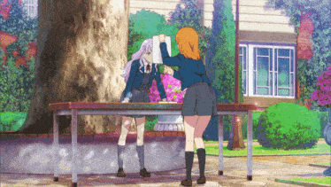 two anime girls are standing next to each other on a table