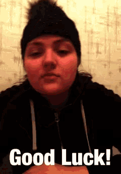 a woman wearing a black hat and a black jacket says " good luck "