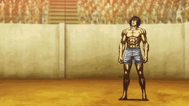 a man without a shirt is standing in front of a crowd in a stadium .