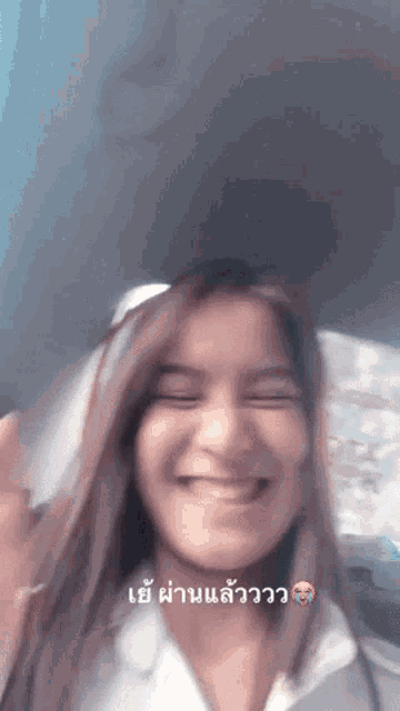 a woman in a white shirt is smiling in a blurry photo with chinese writing