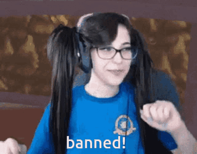 a girl wearing headphones and a blue shirt that says banned on it