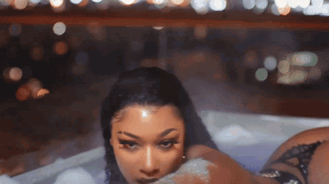 a woman is laying in a bathtub filled with foam