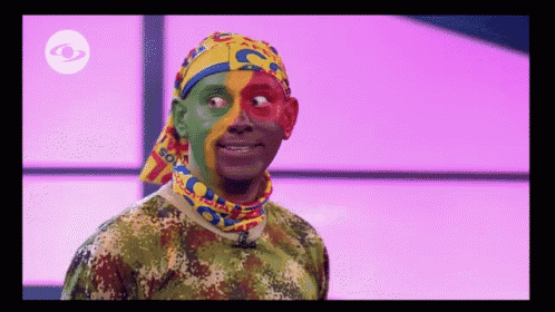 a man wearing a camouflage shirt and a headband with the letter c painted on his face