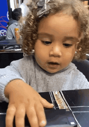 a little girl is playing with a cell phone