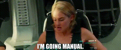 a woman in a black tank top is sitting in a chair and says `` i 'm going manual '' .