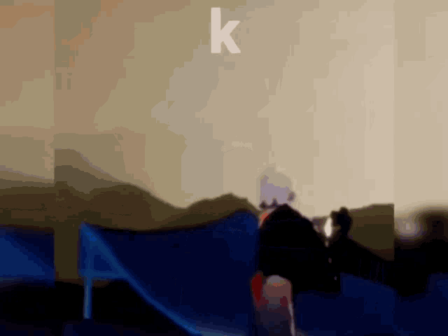 a person is riding a skateboard down a ramp with the letter k above them .