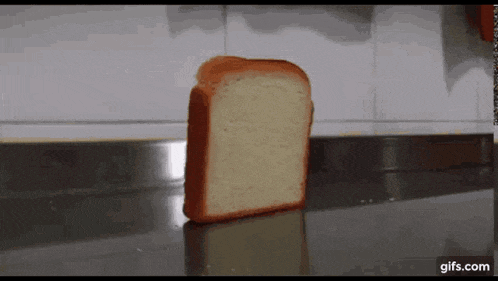 a slice of bread is sitting on a counter in front of a wall .