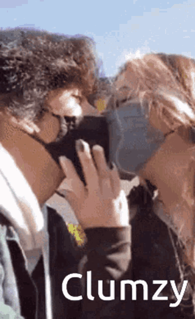 a man and a woman wearing face masks are kissing each other