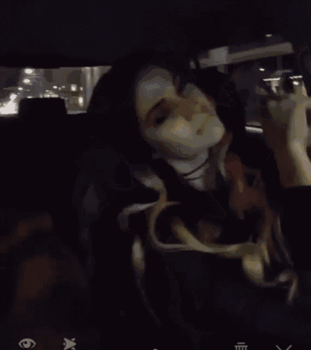 a woman is sitting in the back seat of a car with her eyes visible