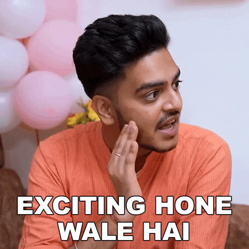 a man in an orange shirt says exciting hone wale hai in front of pink balloons