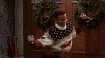 a man in a christmas sweater is standing in front of a door with the words `` got that money '' .