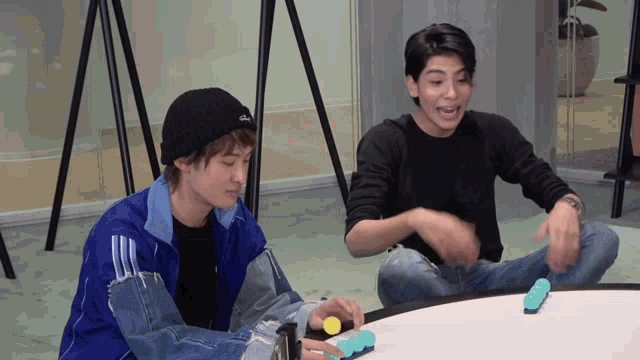 two young men playing a game with one wearing a beanie that says ' a ' on it