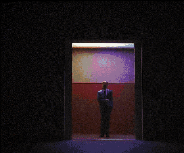 a man in a suit and tie is standing in an elevator