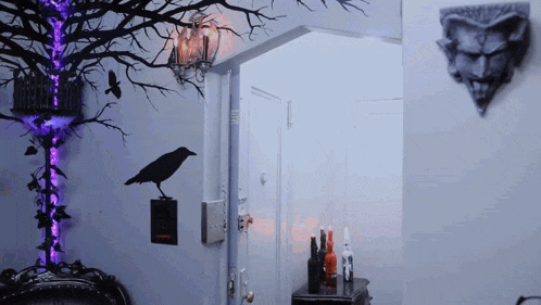 a black bird is sitting on a wall next to a purple light