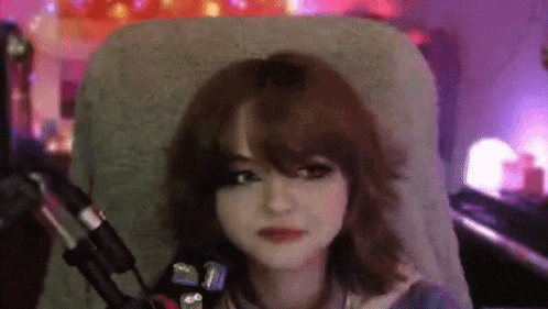 a woman is sitting in a chair with a microphone in front of her .