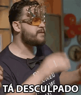 a man with a beard wearing sunglasses and a crown says ta desculpado