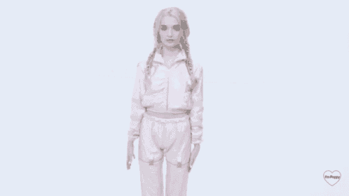 a woman wearing a pink jacket and pants is standing on a white background .