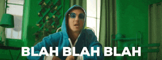 a man wearing a blue hoodie and sunglasses is standing in a green room .