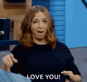 a woman is sitting on a couch making a funny face and saying `` i love you '' .