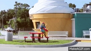a giant ice cream cone is in front of a makeagif.com website