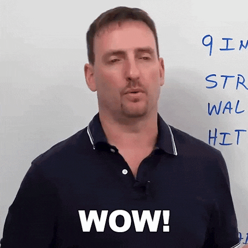 a man is standing in front of a white board and says wow