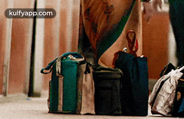 a person is standing next to a pile of luggage and bags .