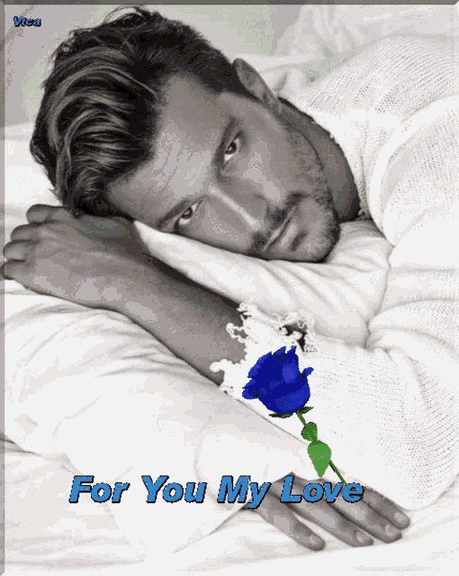 a black and white photo of a man laying on a bed with a blue rose and the words for you my love