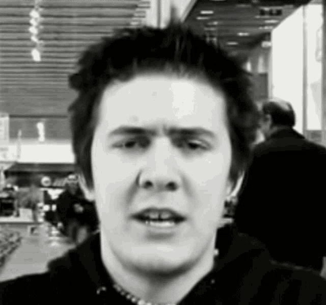 a black and white photo of a young man making a face