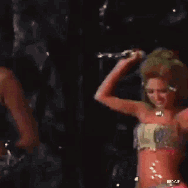 a woman in a striped top is dancing on a stage with the words rbd.gif at the bottom of the image