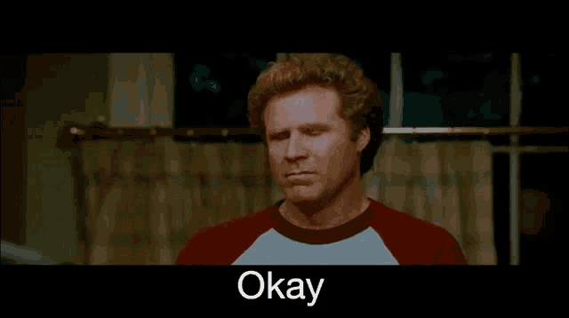 a man in a red shirt with the word okay on the bottom right
