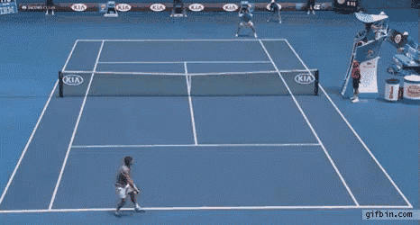 a man stands on a tennis court with kia advertisements on the walls