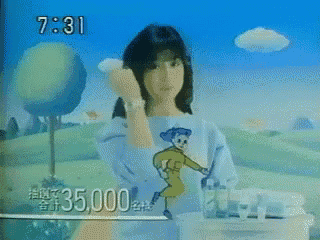 a woman with a cartoon character on her shirt is standing in front of a screen that says 7:31