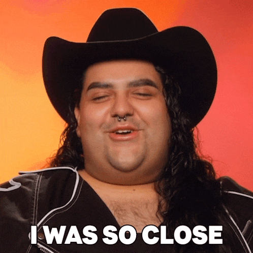 a man with long hair wearing a cowboy hat and a jacket says i was so close