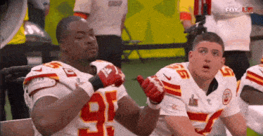 two football players wearing gloves with the number 9 on their jerseys