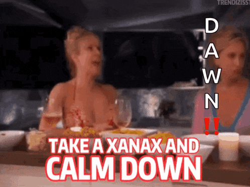 a woman is sitting at a table with the words take a xanax and calm down