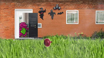 a brick house with a purple dinosaur standing in front of the door