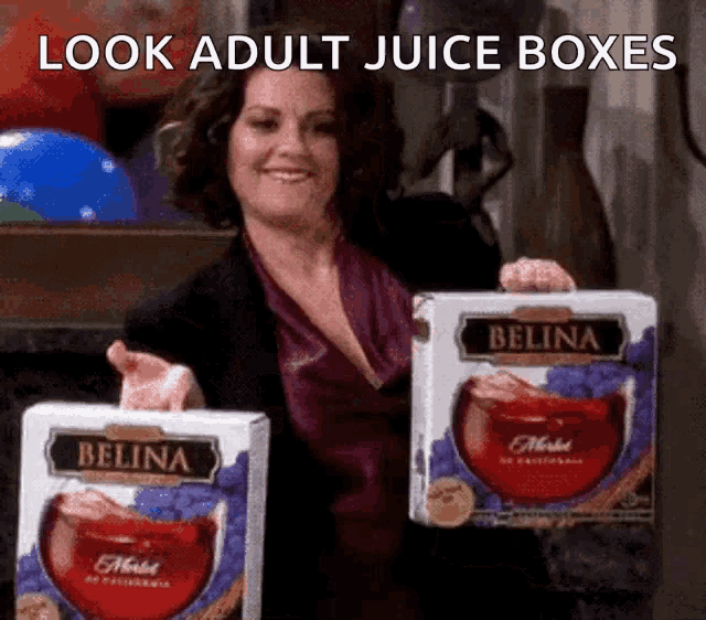 a woman holding up two boxes of belina juice