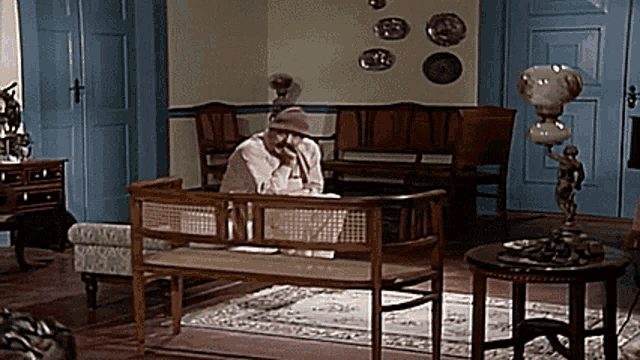a man sits on a bench in a living room