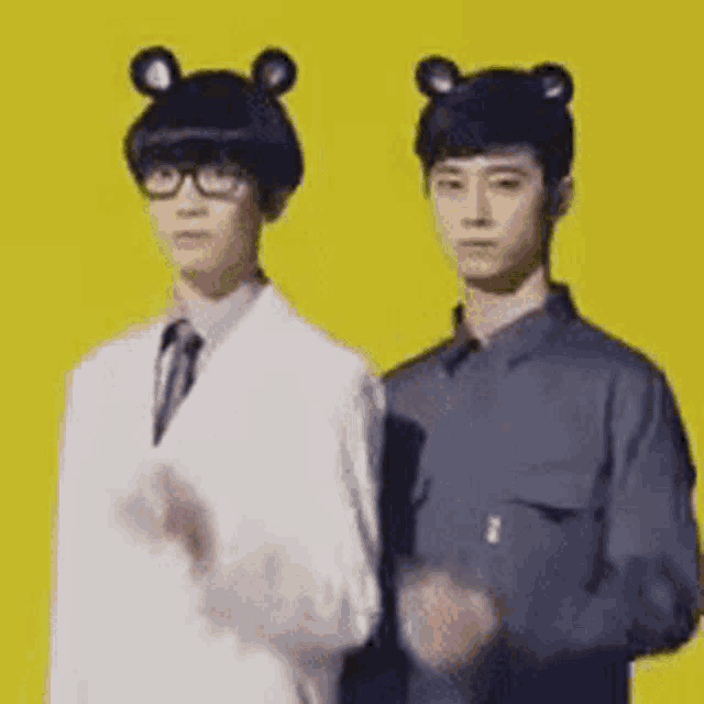 two men are standing next to each other on a yellow background wearing bear hats .
