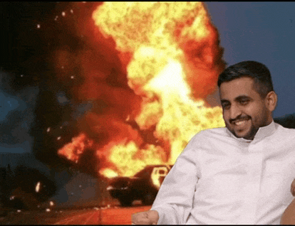 a man in a white shirt is smiling in front of a large explosion