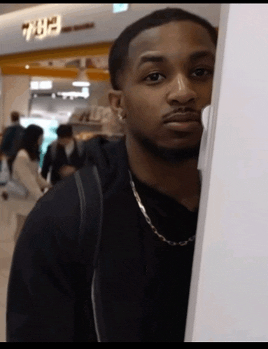 a man stands in front of a sign that says 7:07