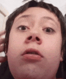 a close up of a person making a funny face with their mouth open .