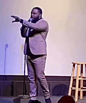 a man in a suit is standing in front of a microphone