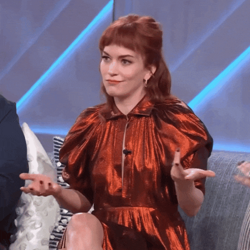 a woman in a red dress sitting on a couch