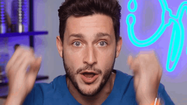 a man with a beard and a blue shirt is making a funny face