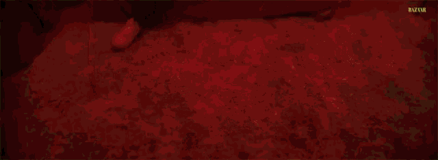 a man is sitting on a bed with his legs crossed in a dark room .